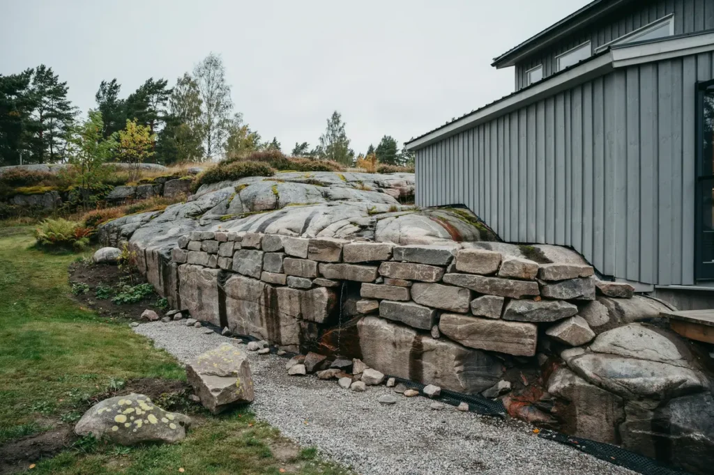 kallmur mot berg vid huset planering och materialval